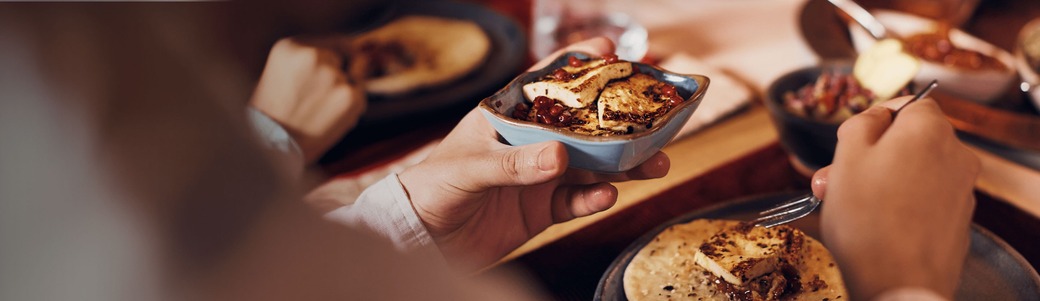 Close-up of a Muslim man eating taboon bread with tofu at home during the iftar meal on Ramadan.